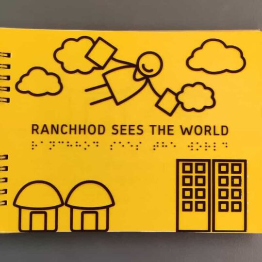 Front page of Ranchhod Sees the world Braille storybook showing the transition of Ranchhod from his village to the city to fulfill his educational dreams