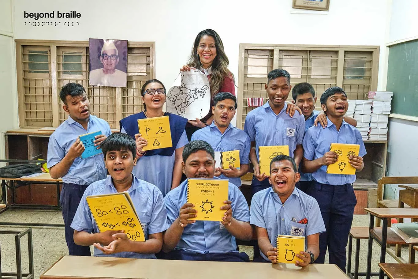 Beyond Braille Founder Ms Nupur Agarwwal with visually impaired children showing different types of beyond Braille books